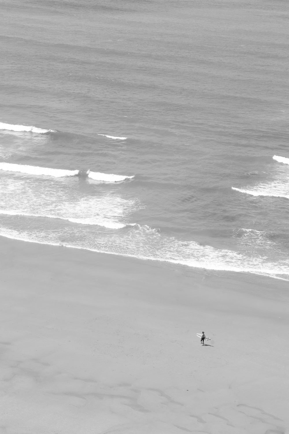 Surfeur marchant sur la plage. Photographie prise sur la plage Erretegia, sur la côte basque en France. Fine art, noir et blanc emma daum.